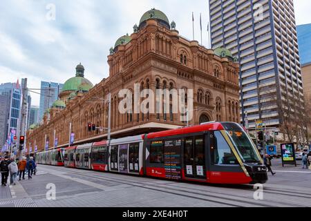 Ein Stadtbahnfahrzeug fährt an Sydneys historischem Department of Lands Building (1892) vorbei. Sydney, Australien Stockfoto