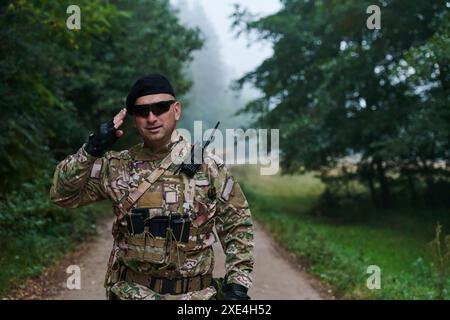 Ein engagierter Soldat grüßt seine Eliteeinheit und zeigt Kameradschaft und Bereitschaft für die gefährlichsten militärischen Operationen Stockfoto