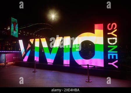 Eine Regenbogenflagge auf einem beleuchteten Schild während des jährlichen „Vivid Sydney“ Festivals in Sydney, Australien, das mit dem „Pride Month“ zusammenfällt Stockfoto