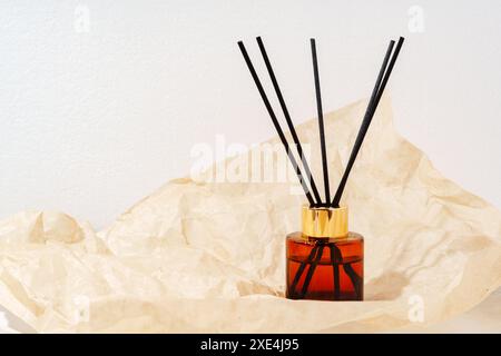 Brauner Glasdiffusor auf zerknittertem Papier Stockfoto