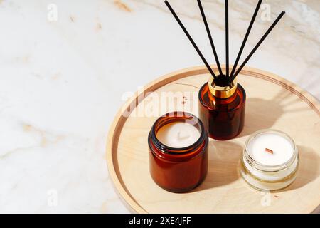 Duftkerzen und Reed Diffusor auf einem Holztablett Stockfoto