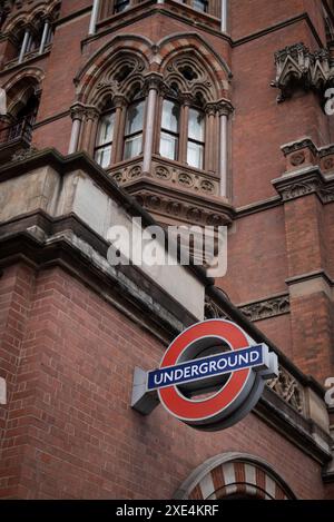 U-Bahn-Station St. Prancras london und rotes U-Bahn-Schild Das Gebäude gegen bewölkten Himmel Stockfoto