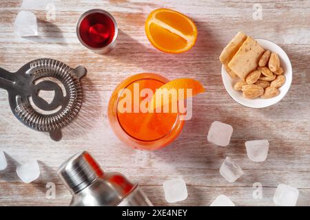 Orangencocktails und ein Shaker, mit einem Jigger campari und Eis, über dem Kopf Stockfoto