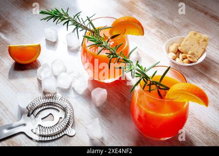 Orangengetränke auf hölzernem Hintergrund, frisch gepresster Saft mit Rosmarin Stockfoto