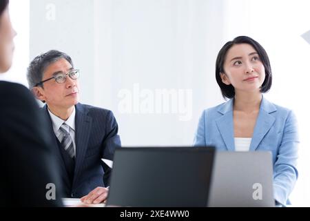 Geschäftsmann und Geschäftsfrau hören sich die Präsentation an Stockfoto
