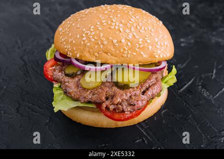 Leckerer Cheeseburger isoliert auf schwarzem Stein Stockfoto