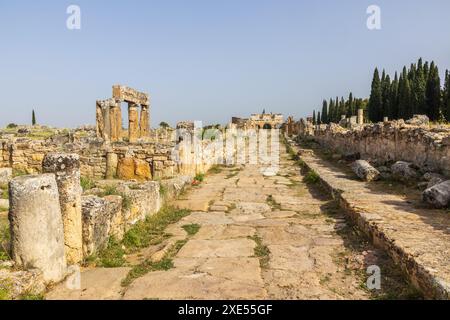 Frontinus-Straße in der alten Ruinenstadt Hierapolis in Türkiye an einem sonnigen Tag, mit sichtbarem Frontinus-Tor. In der Nähe der Stadt Pamukkale Stockfoto