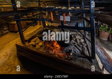 Käseblättert in einem riesigen Topf über dem offenen Feuer auf der Karseggalm und Speckschalen verströmen den Rauch perfekt. Großarl, Salzburg, Österreich Stockfoto