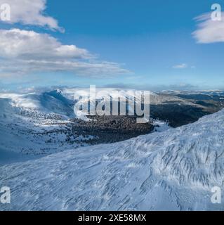 Schnee und Wind bildeten Eisformationen bedeckten Winter-Bergplateau, Gipfel mit Schnee Gesimse in der Ferne. Herrlicher sonniger Tag auf pi Stockfoto