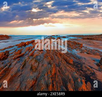 Twilight Ozean Küste mit geripptem stratiform Rock. Stockfoto