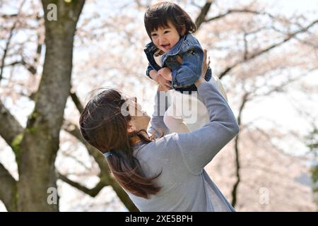 Mutter hebt Kleinkind Stockfoto