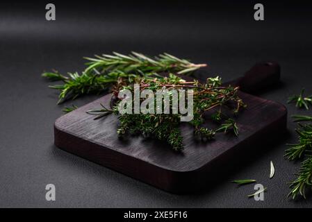 Zweige von frischem grünem Thymian auf einem hölzernen Schneidebrett Stockfoto