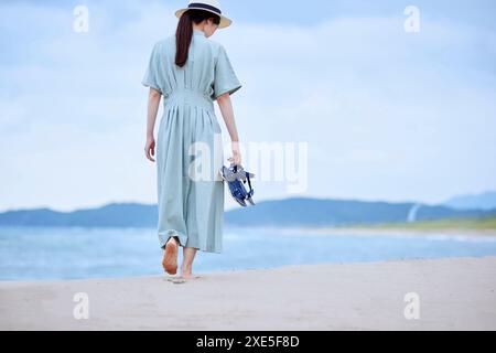 Eine junge Japanerin, die einen Urlaub am Meer genießt Stockfoto