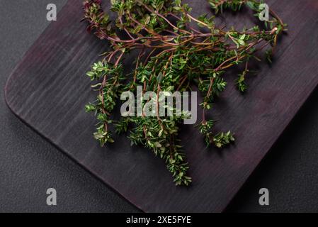 Zweige von frischem grünem Thymian auf einem hölzernen Schneidebrett Stockfoto
