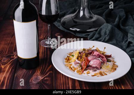 Italienisches Vitello Tonnato mit Flasche und Glas Wein Stockfoto