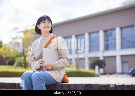 Junge japanische Universitätsstudenten genießen das Leben auf dem Campus Stockfoto