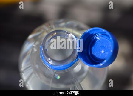 Dresden, Deutschland. Juni 2024. Eine Wasserflasche mit offenem Deckel steht auf einem Tisch. Um Abfall auf dem Land zu reduzieren, werden ab dem 3. Juli 2024 lose Deckel für bestimmte Getränke verboten. Dies gilt für Einwegverpackungen, die ganz oder teilweise aus Kunststoff bestehen - wie Saftkartons oder PET-Einwegflaschen - mit einem Volumen von bis zu drei Litern. Robert Michael/dpa/Alamy Live News Stockfoto
