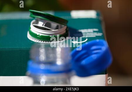 Dresden, Deutschland. Juni 2024. Ein Saftkarton und eine Wasserflasche mit offenen Deckeln stehen auf einem Tisch. Um Abfall auf dem Land zu reduzieren, werden ab dem 3. Juli 2024 lose Kappen für bestimmte Getränke verboten. Dies gilt für Einwegverpackungen, die ganz oder teilweise aus Kunststoff bestehen - wie Saftkartons oder PET-Einwegflaschen - mit einem Volumen von bis zu drei Litern. Robert Michael/dpa/Alamy Live News Stockfoto