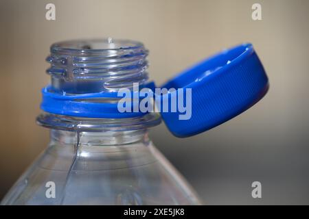 Dresden, Deutschland. Juni 2024. Eine Wasserflasche mit offenem Deckel steht auf einem Tisch. Um Abfall auf dem Land zu reduzieren, werden ab dem 3. Juli 2024 lose Deckel für bestimmte Getränke verboten. Dies gilt für Einwegverpackungen, die ganz oder teilweise aus Kunststoff bestehen - wie Saftkartons oder PET-Einwegflaschen - mit einem Volumen von bis zu drei Litern. Robert Michael/dpa/Alamy Live News Stockfoto