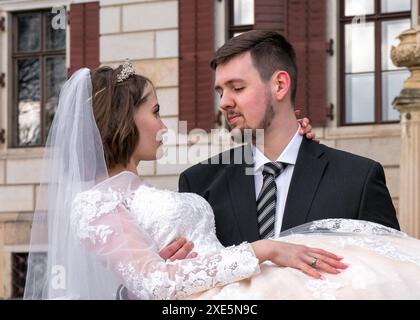 Der Bräutigam hält die junge Braut sanft in den Armen. Nahaufnahme. Liebe Stockfoto