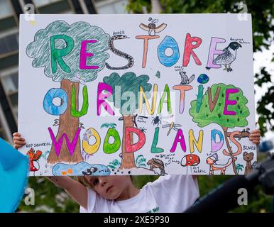 London, Großbritannien. Juni 2024. Umweltschützer halten ein Schild bei der Demonstration Restore Nature Now in London und rufen zu dringenden politischen Maßnahmen in Bezug auf Natur- und Klimakrisen auf. Stockfoto