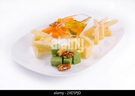 Käseplatte mit Honig, Nüsse auf weißer Platte Stockfoto