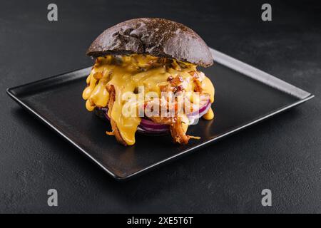 Schwarzer Burger mit Schweinefleisch auf Schwarz Stockfoto