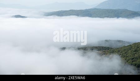 Berggipfel, bedeckt mit einer Schicht Nebel und Nebel bei Sonnenaufgang. Naturlandschaft Stockfoto