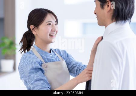 Die Frau trägt die Krawatte des Mannes Stockfoto