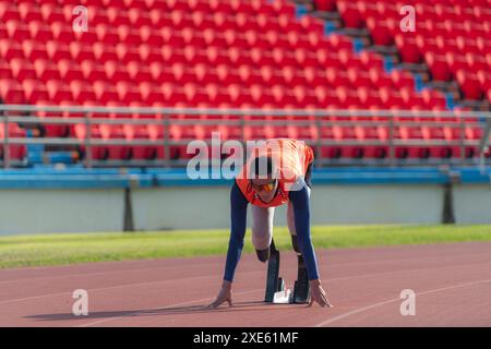 Behinderte Athleten bereiten sich in der Startposition vor, um auf der Stadionstrecke zu laufen Stockfoto