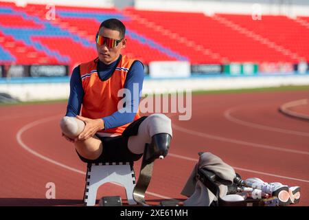 Behinderte Athleten bereiten sich in der Startposition vor, um auf der Stadionstrecke zu laufen Stockfoto