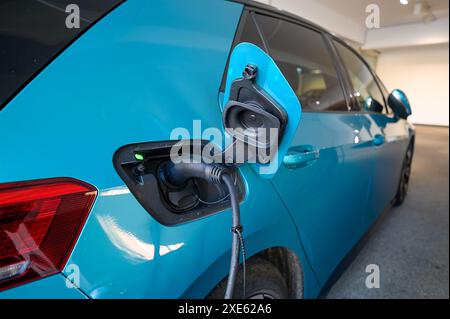 Elektrische Auto-Aufladung in der Tiefgarage Haus mit Steckdose Ladestation. Batterie EV Fahrzeugstativ Stockfoto