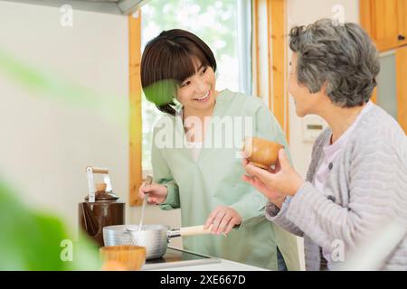 Enkel kocht für seine Großmutter Stockfoto