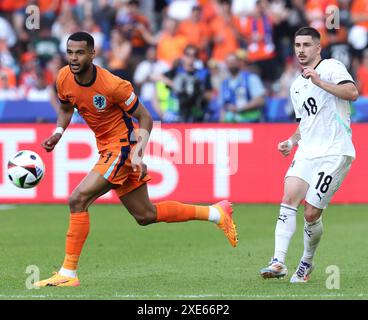 BERLIN, DEUTSCHLAND - 25. JUNI: Cody Gakpo aus den Niederlanden mit Romano Schmid aus Österreich während des Gruppenspiels D - UEFA EURO 2024 zwischen den Niederlanden und Österreich im Olympiastadion am 25. Juni 2024 in Berlin. (Foto: Peter Lous/BSR Agency) Stockfoto