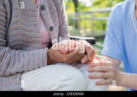 Pflegekraft, die die Hand der Seniorin hält Stockfoto