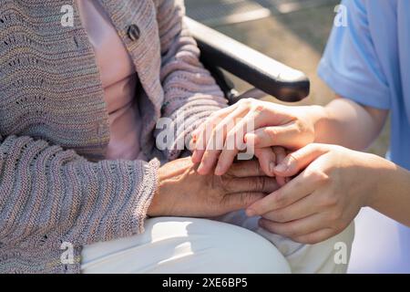 Pflegekraft, die die Hand der Seniorin hält Stockfoto