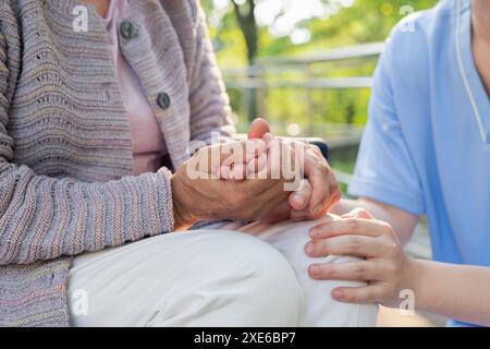 Pflegekraft, die die Hand der Seniorin hält Stockfoto