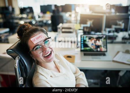 Frau, Porträt und Papier auf der Stirn im Büro mit fröhlicher Erinnerung, Arbeitspause und Comedy-Streich am Schreibtisch. Geschäftsmann, Mädchen lächeln und Haftnotiz Stockfoto