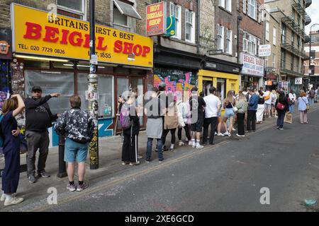 Kunden stehen am geschlossenen Beigel Shop vorbei, um Beigel von Beigel Bake in der Brick Lane zu kaufen Stockfoto