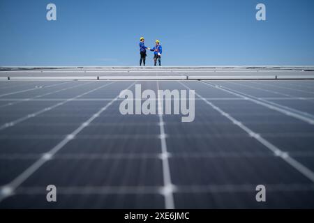 Beide Techniker arbeiten an Photovoltaik-Solarpaneelen Stockfoto