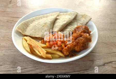 Quesadilla mexikanische Pizza mit Püree mit scharfem Hähnchenpüree und Pommes Frites und Barbecue-Buffalos, die mit einem Salat auf dem Teller belegt werden Stockfoto