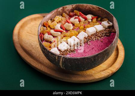 Gesunder Smoothie zum Frühstück mit Rosinen und Cashewkernen in Kokosnussschale Stockfoto