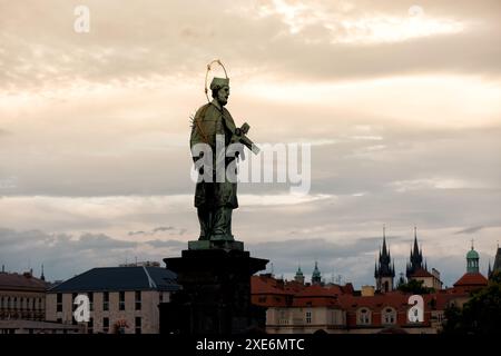 Bronzestatue des heiligen Johannes von Nepomuk auf der Karlsbrücke mit Prags Skyline im Hintergrund, Tschechische Republik Stockfoto