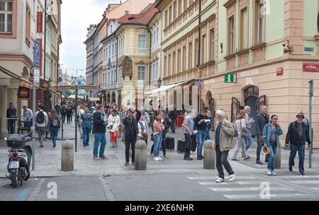 Prag, Tschechische Republik - 27. Mai 2019: Touristen schlendern entlang einer belebten Straße, vorbei an Restaurants und Geschäften in Prag Stockfoto