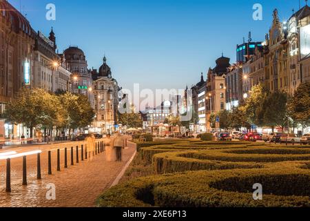 Prag, Tschechische Republik - 21. Mai 2019: Touristen schlendern auf dem Wenzelsplatz inmitten historischer Architektur und glühender Schaufensterfronten bei Sonnenuntergang Stockfoto