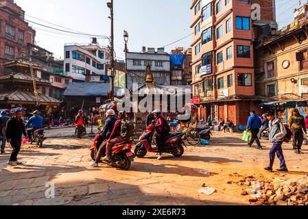 Viel Verkehr mit Motorrädern und Fußgängern auf einer staubigen Marktstraße, warmes Licht der morgendlichen Rush Hour, Kathmandu, Nepal, Asien Copyright: CasparxSchl Stockfoto