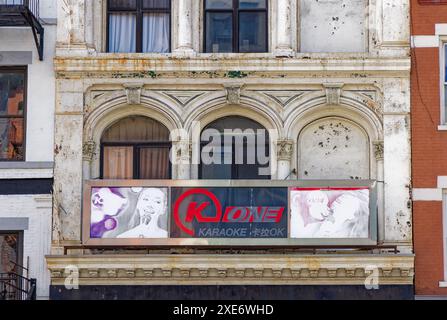 NYC Chinatown: 97 Bowery, ein Wahrzeichen von NYC, gusseisernes Loft-Gebäude, befindet sich in schäbigem Zustand, mit Graffiti und abblätternder weißer Farbe bestückt. Stockfoto