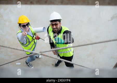 Blick von oben auf einer Baustelle diskutieren ein Ingenieur und Architekt auf einem Laptop. Stockfoto