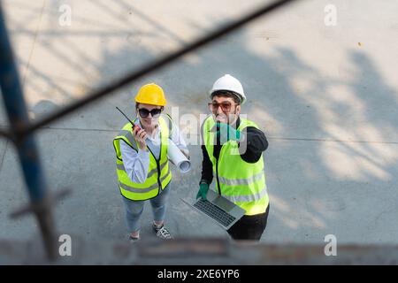 Blick von oben auf einer Baustelle diskutieren ein Ingenieur und Architekt auf einem Laptop. Stockfoto