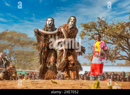 Maskierte Tänzer mit Schlange, die traditionelle Kulamba-Zeremonie der Chewa aus Sambia, Mosambik und Malawi, die jährlich am letzten Samstag stattfindet Stockfoto